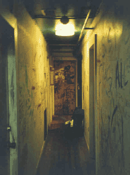 The empty hallway bore the marks of a life lived with humanity. The purpose for the writing was ambiguous; was it degradation or respect that led people to do it?